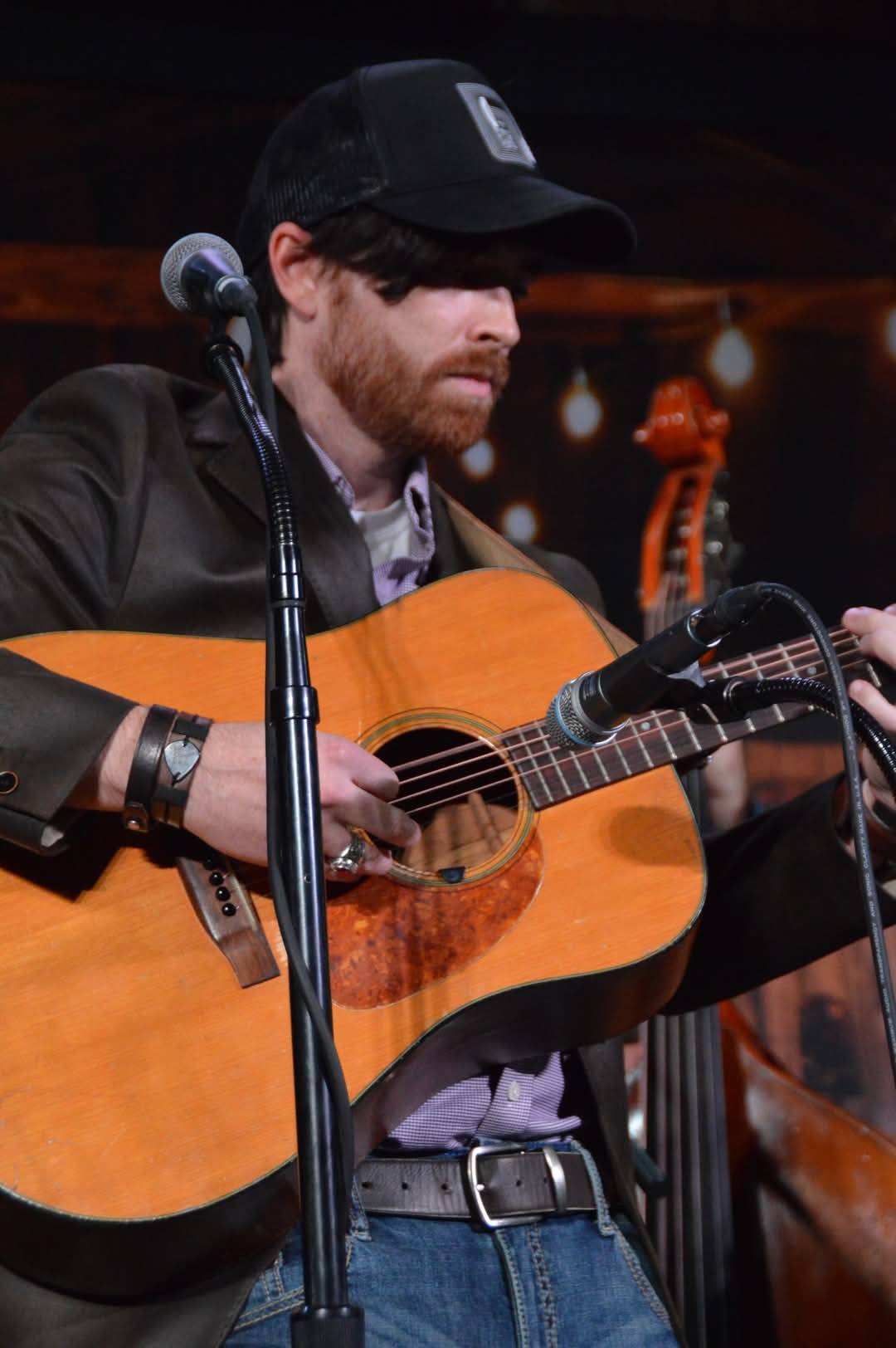 Justin Jones flatpicking his guitar on stage